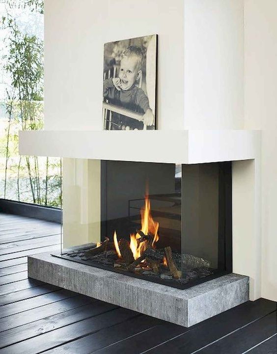 a modern fireplace with a concrete platform encased in glass is a very chic and refined idea with a modern feel