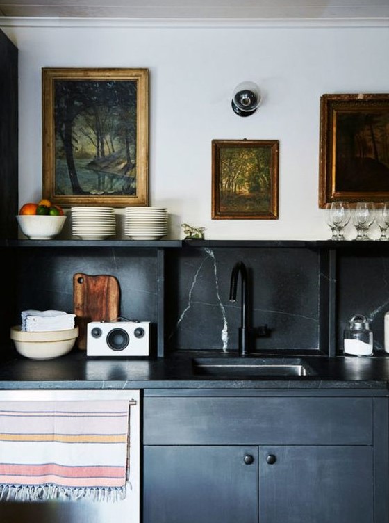 a black vintage-inspired kitchen with a black marble backsplash and countertops for a refined touch