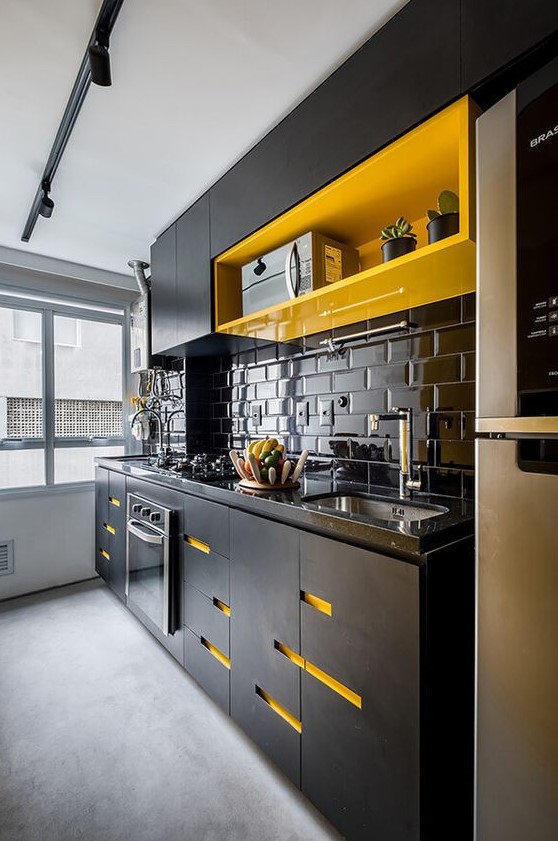 a bold and super modern black and yellow kitchen with a glossy black subway tile backsplash and bold neon yellow touches