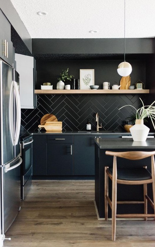 a-chic-black-kitchen-with-black-cabinets-a-tile-backsplash-concrete-countertops-and-touches-of-light-colored-wood.jpg