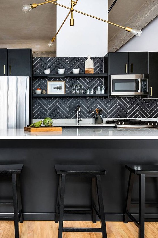 a chic black kitchen with white countertops, a black herringbone backsplash and an elegant gilded chandelier is elegant and refined
