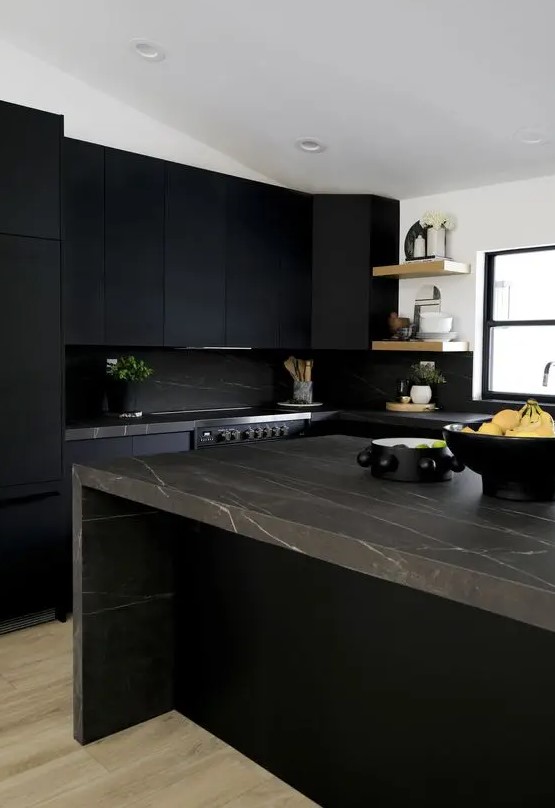 a-matte-black-kitchen-with-a-black-marble-backsplash-and-brown-marble-countertops-open-shelves-and-some-potted-plants.jpg