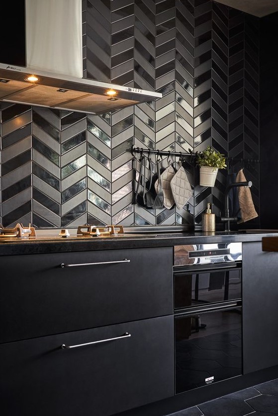 a metal black kitchen with black quartz countertops, a black herringbone backsplash with glossy and matte touches