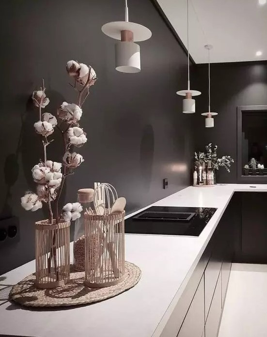 a moody black kitchen with black walls, glossy cabinets, white countertops and white pendant lamps is a stylish idea