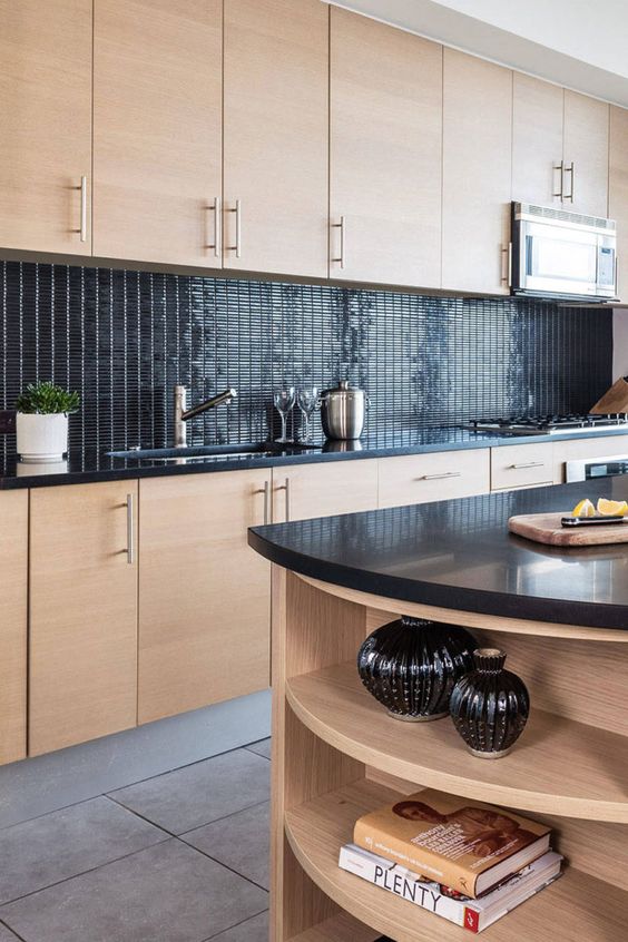 an MDF kitchen with glossy back tiles on the backsplash and black countertops, a matching kitchen island