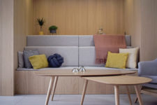 02 The living room is minimalsit, with a built-in sofa and a low table, with colorful pillows and greenery