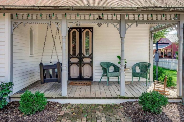 The porch features original black and pink doors, there's a hanging daybed and a green woven chair for a cozy feel The porch features original black and pink doors, there's a hanging daybed and a green woven chair for a cozy feel