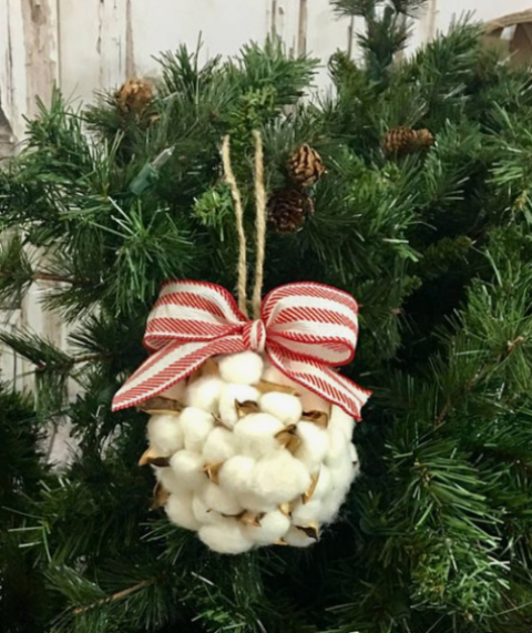 a cute and fluffy Christmas ornament of cotton and a striped red and white bow looks very fluffy and very cool