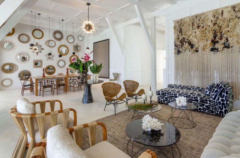 a quirky neutral layout with a living room and a dining space with eclectic decor, lots of mirrors and lamps and much texture