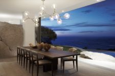 03 The dining space is opened to outdoors, there’s a dark dining set and a large bubble chandelier
