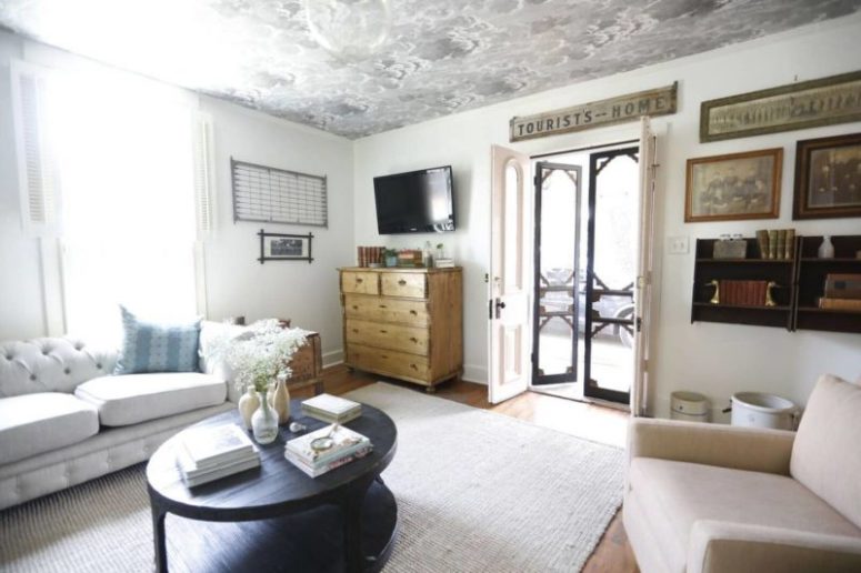 The living room features neutral furniture, some shabby chic items, a printed ceiling and some black touches for drama The living room features neutral furniture, some shabby chic items, a printed ceiling and some black touches for drama