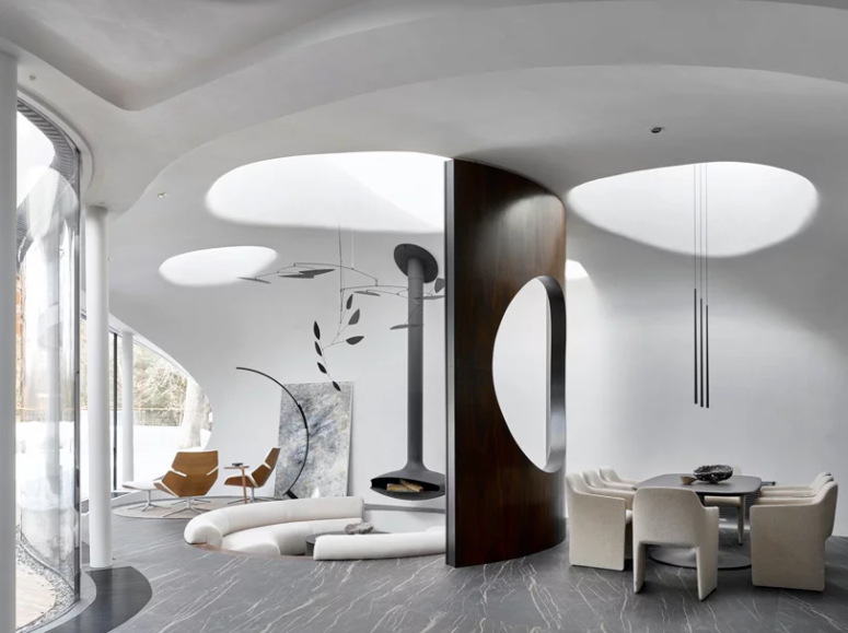 The main layout unites several zones including a dining space with a dakr table and neutral chairs and a conversation put with a suspended hearth