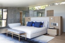 05 The master bedroom features a bathtub, there’s a bright rug and a bed with blue pillows