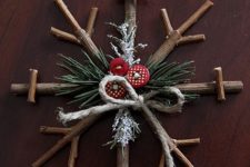05 a simple stick snowflake ornament with evergreens, red buttons and twine can be easily DIYed by you or your kids