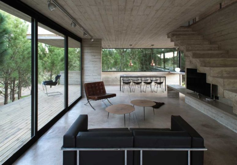 The main open layout includes a dining space and a living room, with a black dining set, coffee tables and a black leather sofa The main open layout includes a dining space and a living room, with a black dining set, coffee tables and a black leather sofa