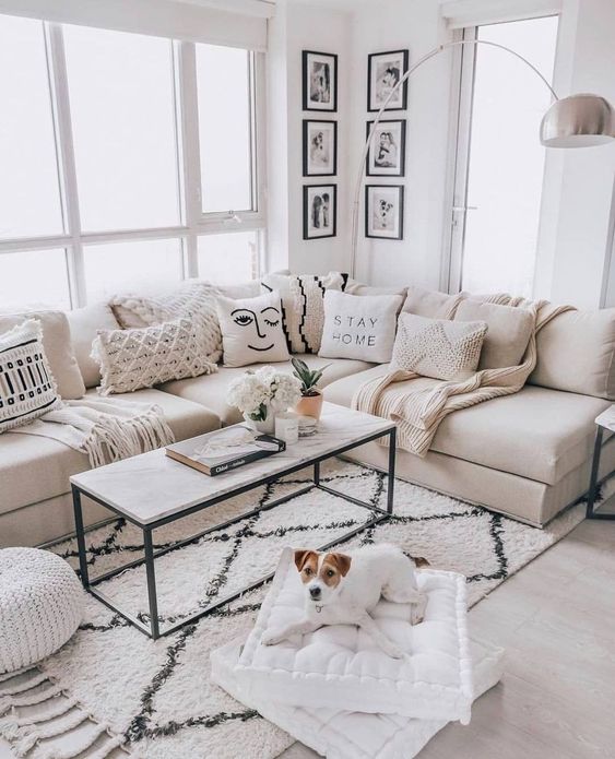 a contemporary living room with touches of black for drama, plenty of textural pillows and some lamps