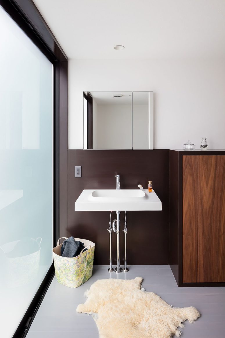 The bathroom is seamlessly integrated into the house, the sink is out here, and all the rest is hidden behind a frosted glass door The bathroom is seamlessly integrated into the house, the sink is out here, and all the rest is hidden behind a frosted glass door