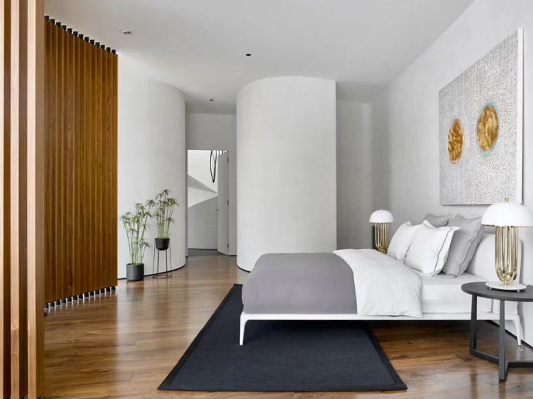 The master bedroom is done with a cool bed, a statement artwork and rugs and looks cozy and private