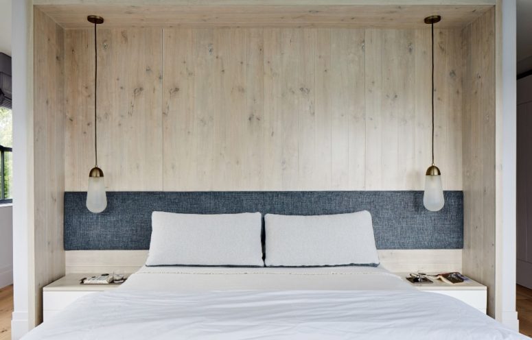 The bedroom features wood, a comfy bed and pendant lamps