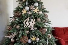 11 a farmhouse Christmas tree with metallic and oversized vine ornaments, wooden signs and snowflakes plus a galvanized bucket base