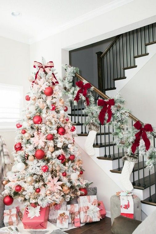 a flocked Christmas tree with lights, oversized pink ornaments and smaller metallic ones plus pink flowers for a glam look