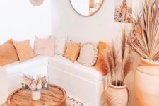 12 a neutral and warm-toned boho living room with warm touches, rugs, a table and a terra cotta pot plus pampas grass