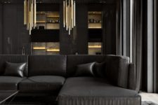 14 a luxurious dark living room with a large black sectional sofa, a faux fur rug, statement gold chandeliers and raw concrete