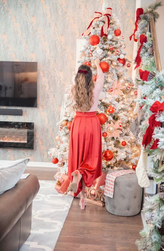 a glam Christmas tree with lights, oversized red ornaments, metallic ones and fabric bows