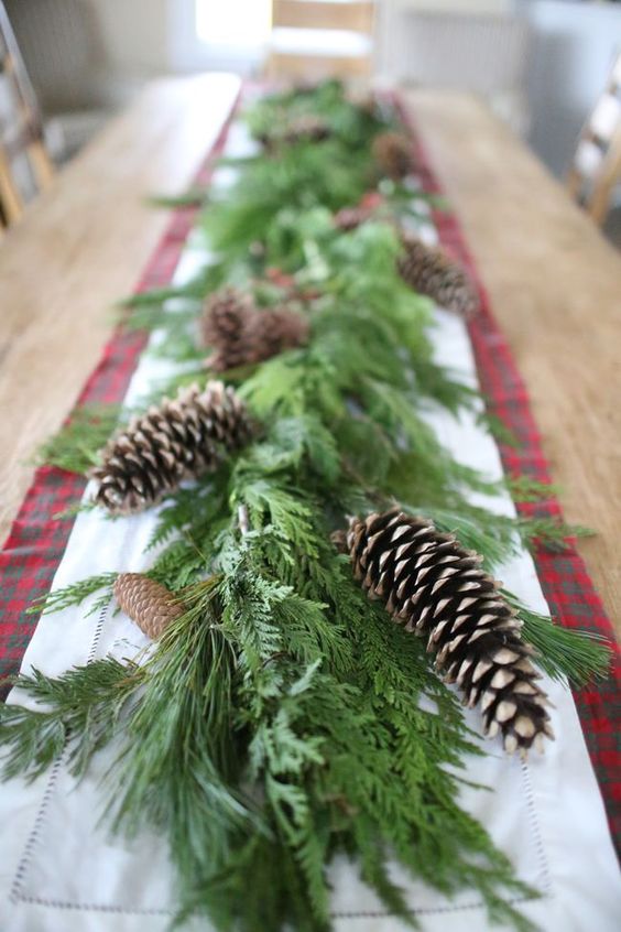 a lush greenery garland with pinecones is a cool table decoration for Christmas