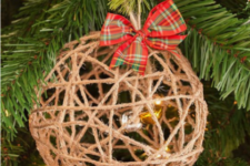 18 a yarn Christmas ball ornament with bells inside and a red plaid bow on top is a pretty and whimsy idea