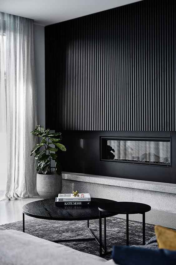 a minimalist living room with stone, metal and wood done in greys and black is chic and stylish