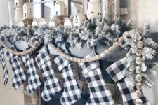 19 buffalo check stockings, flocked evergreens and wooden bead garlands for Christmas mantel decor