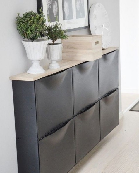 a chic IKEA Trones storage cabinet painted black and given a new top that contrasts it a lot