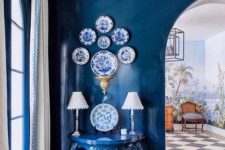 26 a space fully painted in classic blue – the walls, the ceiling an even a matching console table plus blue and white decorative plates