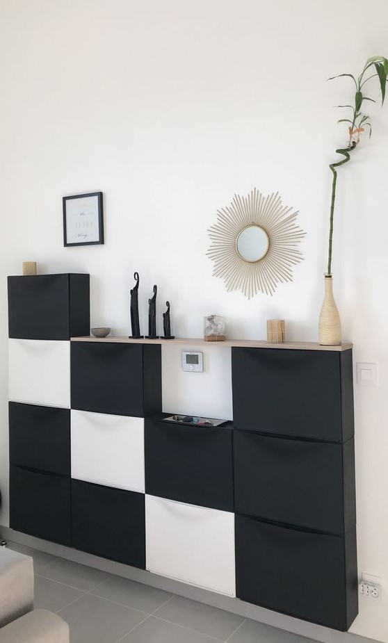 a contemporary living room console made up of several IKEA Trones units in black and white and with a wooden tabletop