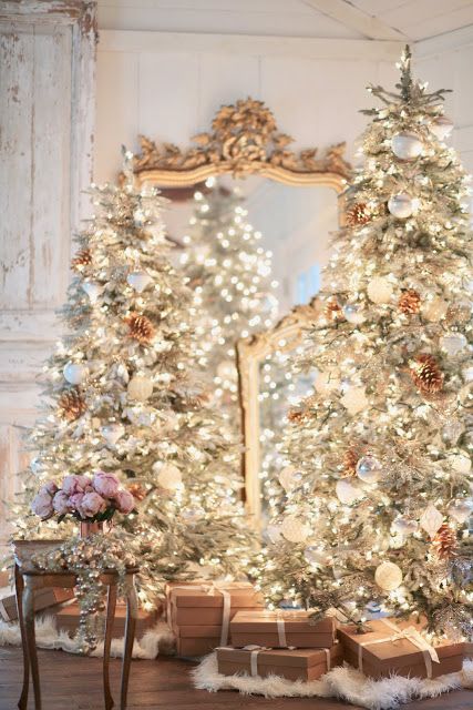 a duo of shiny holiday trees with pinecones and white and silver ornaments looks very beautiful and cozies up the space
