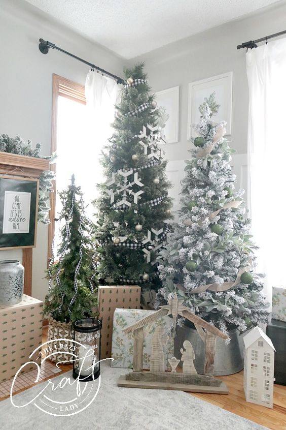 a farmhouse Christmas tree display with trees decorated in various ways and some gift boxes under the trees