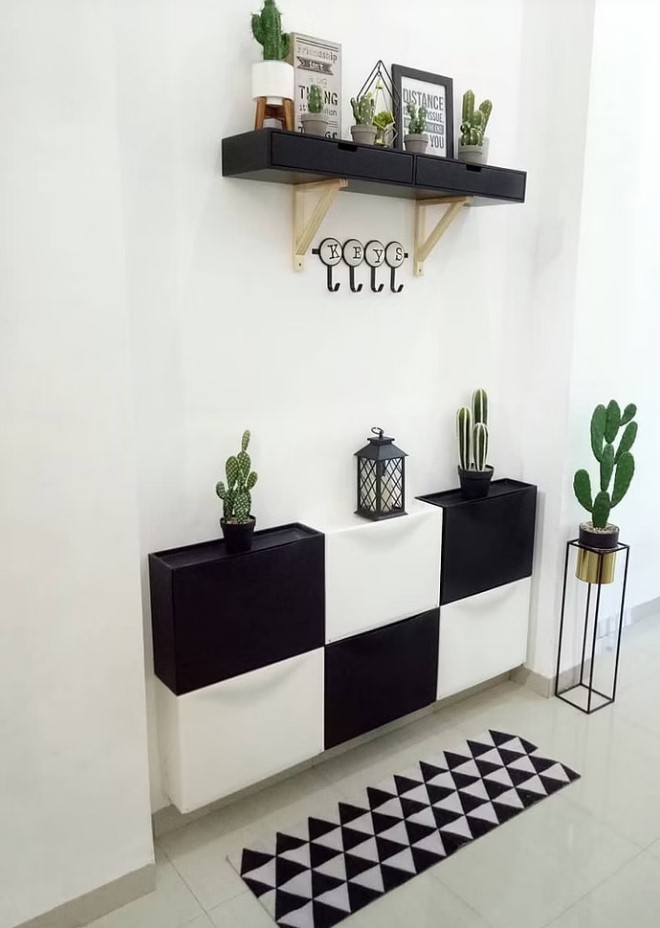 a modern entryway with a black adn white checked IKEA Trones piece, a printed rug and a smaller storage unit