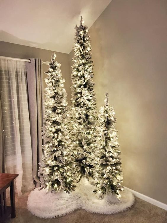 a stylish Christmas tree cluster, flocked trees with lights, is a super cool and catchy idea for holiday decor