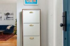 an IKEA Bissa hack with a wooden waterfall countertop and gilded knobs is a cool storage unit for a contemporary space