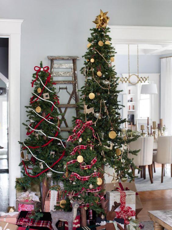 multiple Christmas trees decorated with ribbons, ornaments and stars on top are amazing for bold rustic decor