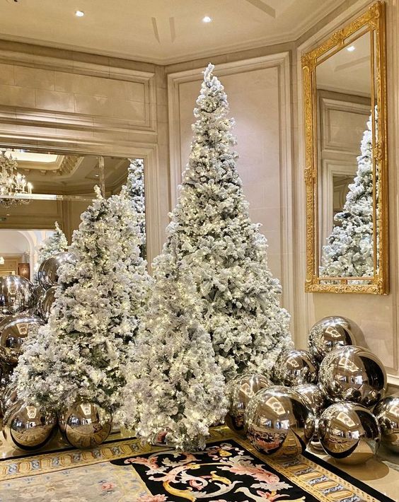 multiple flocked Christmas trees with lights and silver balls around are amazing, they create a chic and elegant look