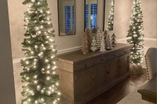 two matching Christmas trees with lights and baskets are great for rustic Christmas decor