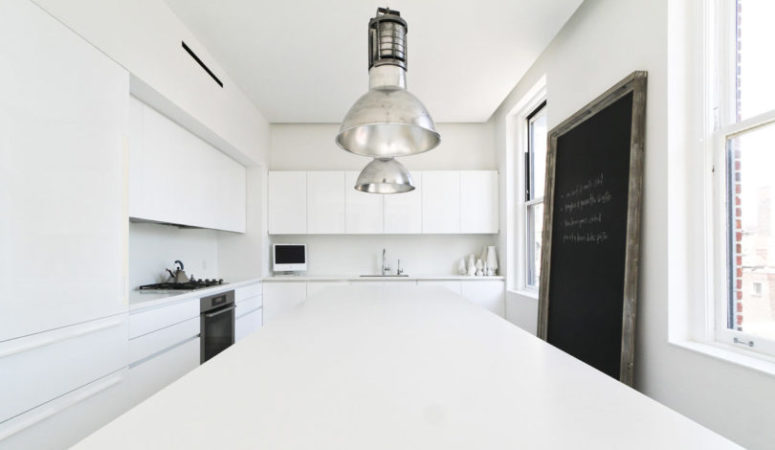 The kitchen is purely white, with vintage metal lamps and some stylish appliances