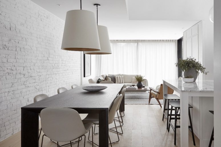 The open space unites the kitchen, dining and living room, brick walls bring texture to the space