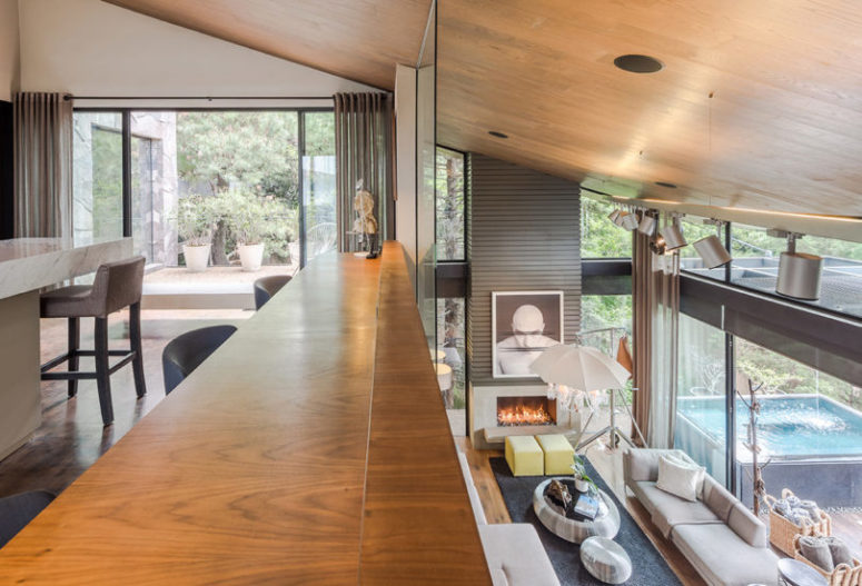 The kitchen is placed on the next level and here you can see a large kitchen island with a stone countertop and an entrance to a terrace The kitchen is placed on the next level and here you can see a large kitchen island with a stone countertop and an entrance to a terrace