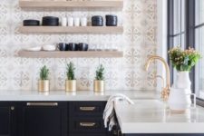 03 a navy kitchen with a thick white countertop, gold fixtures, thick open shelving and mosaic tiles