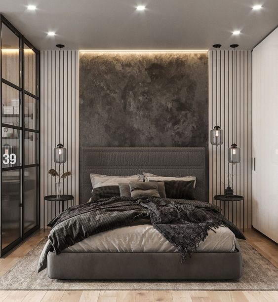 a cozy moody bedroom with a fabric upholstered wall, an upholstered bed and cool lamps