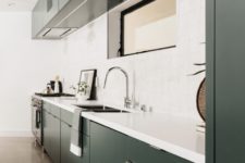 05 The kitchen is designed in dark green and white, with a chic tile backsplash and a matching white countertop