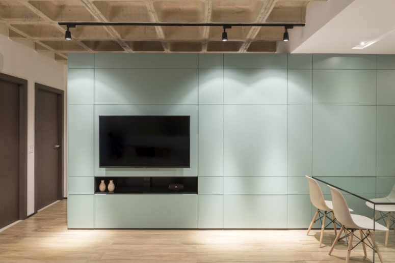 The large custom cabinet serves as an entertainment center for the living room and as a space divider The large custom cabinet serves as an entertainment center for the living room and as a space divider